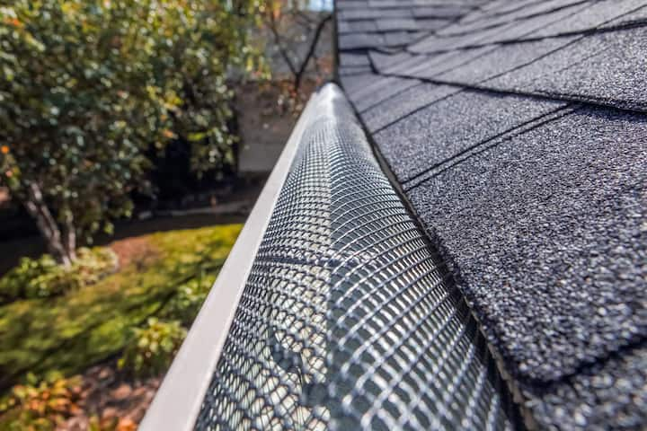 A contractor demonstrating the effectiveness of a gutter guard to a potential client in Port Saint Lucie